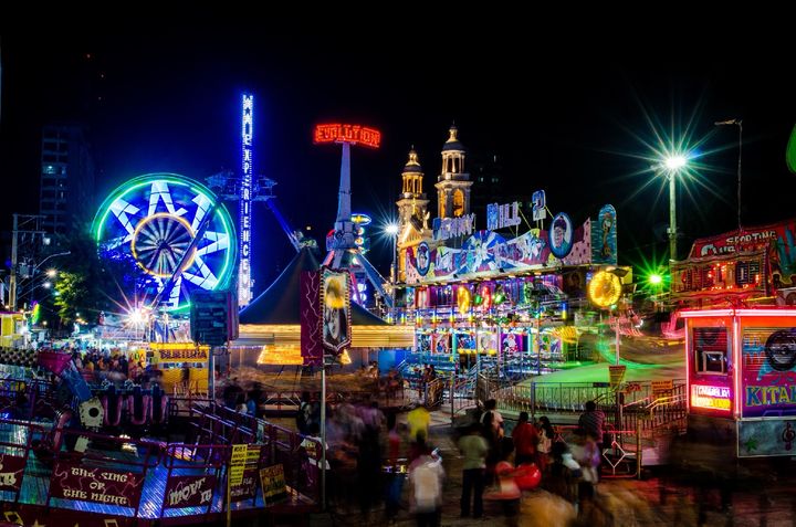Roda-gigante e brinquedos iluminados à noite no Arraial de Nazaré